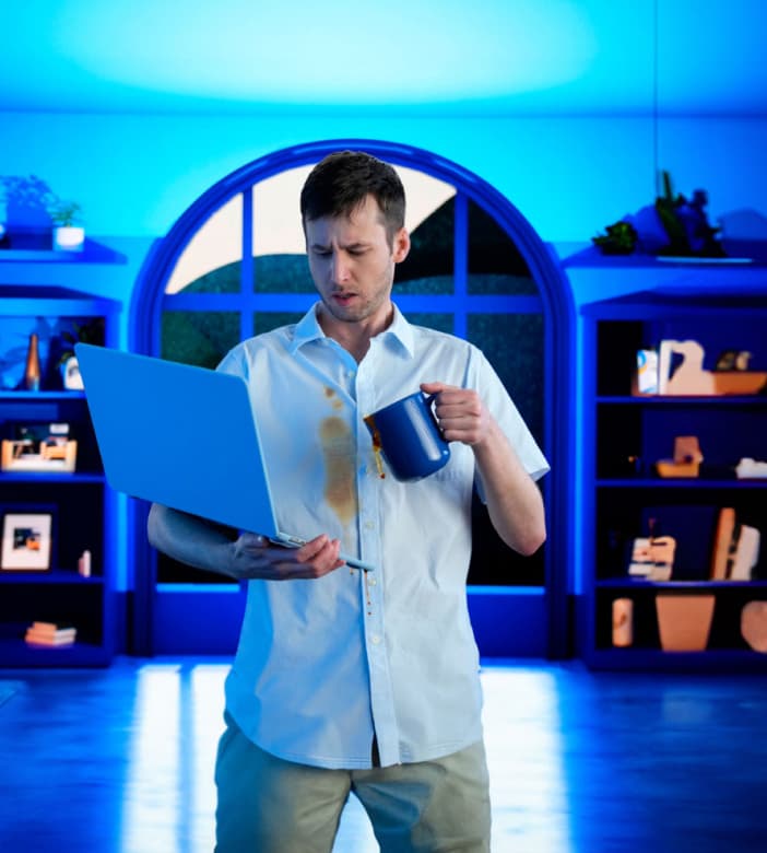 Man spilling coffee on laptop PC.