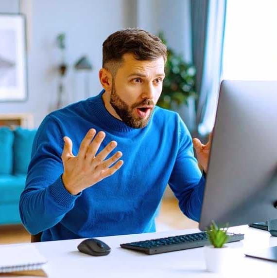 Worried man looking at computer screen.