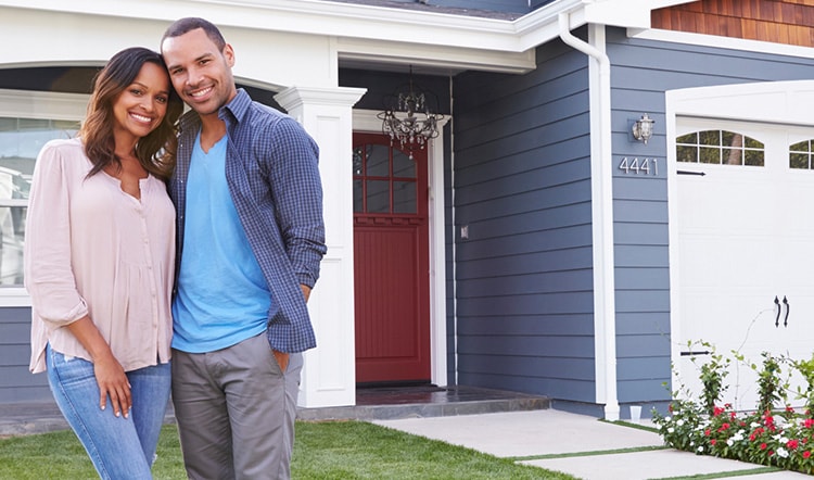 Man and woman in front of house