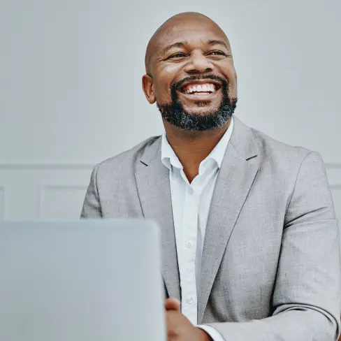 Smiling man working on laptop PC>