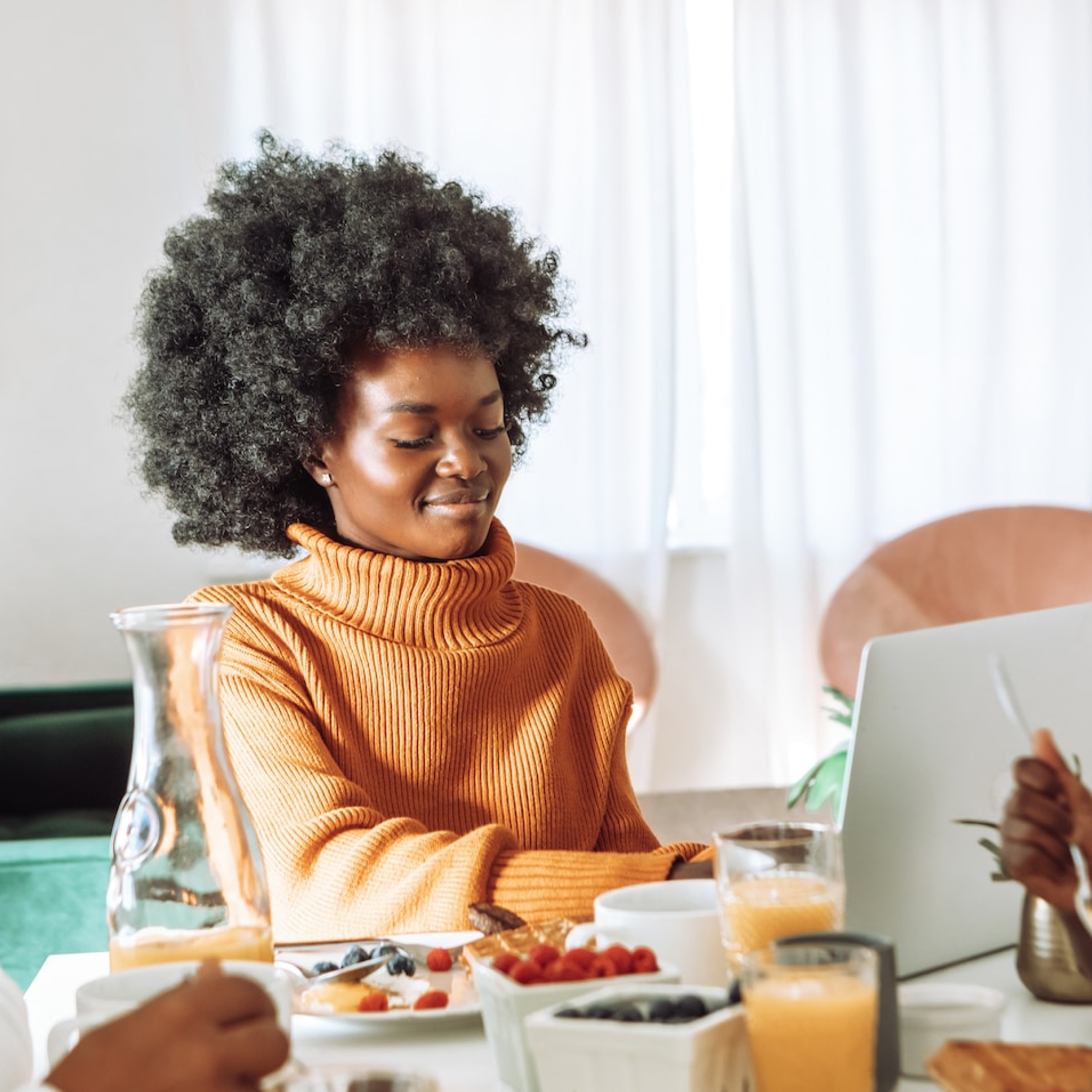 Smiling woman looks at her laptop which uses Carbonite auto backup software.