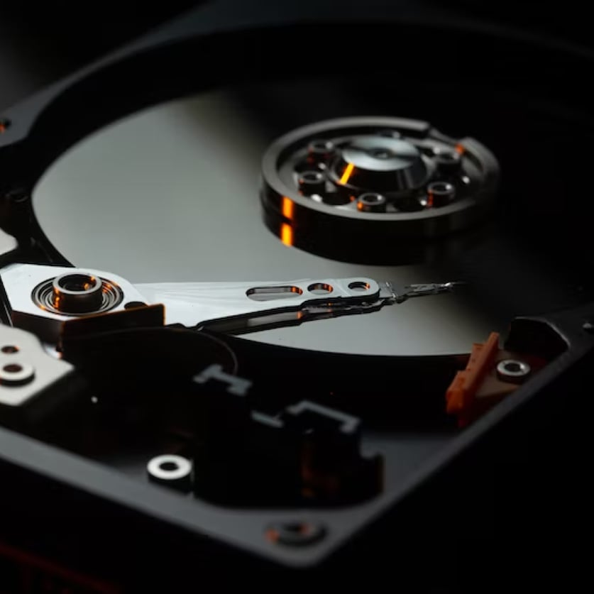 An abstract image of a matte black hard drive with orange light and variegated steel for Carbonite Server Backup.